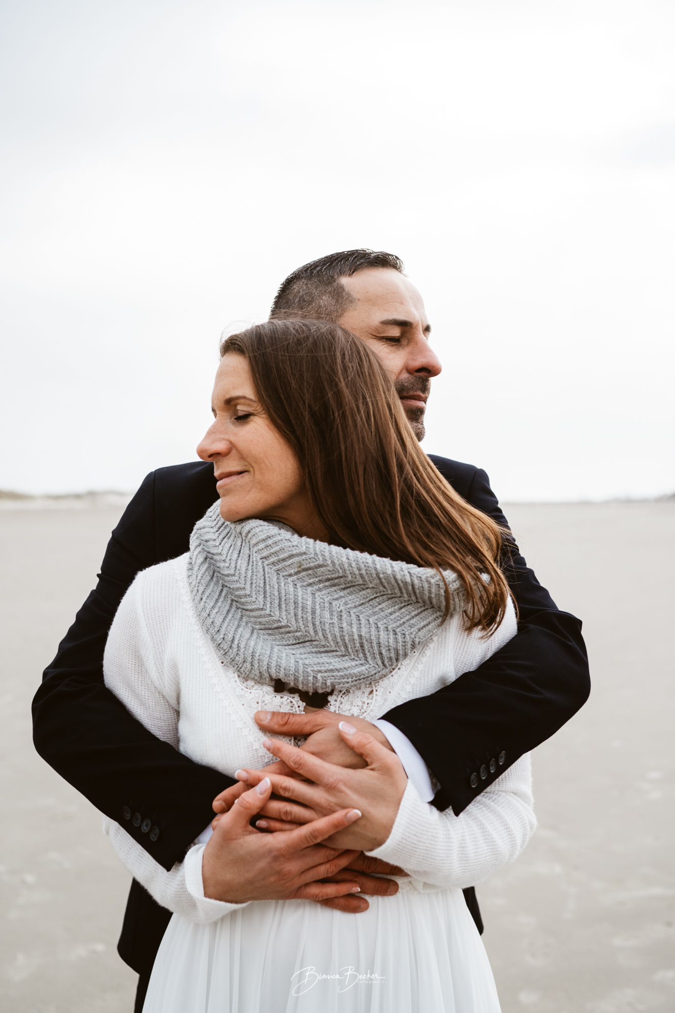 Intimes Brautpaarshooting am weiten Strand von Sankt Peter-Ording bei einer Elopement Hochzeit.